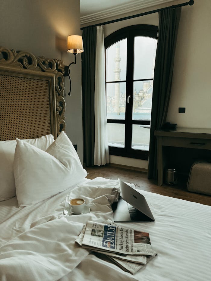 Luxurious hotel bedroom in Istanbul with a cityscape view, ideal for relaxation and work.
