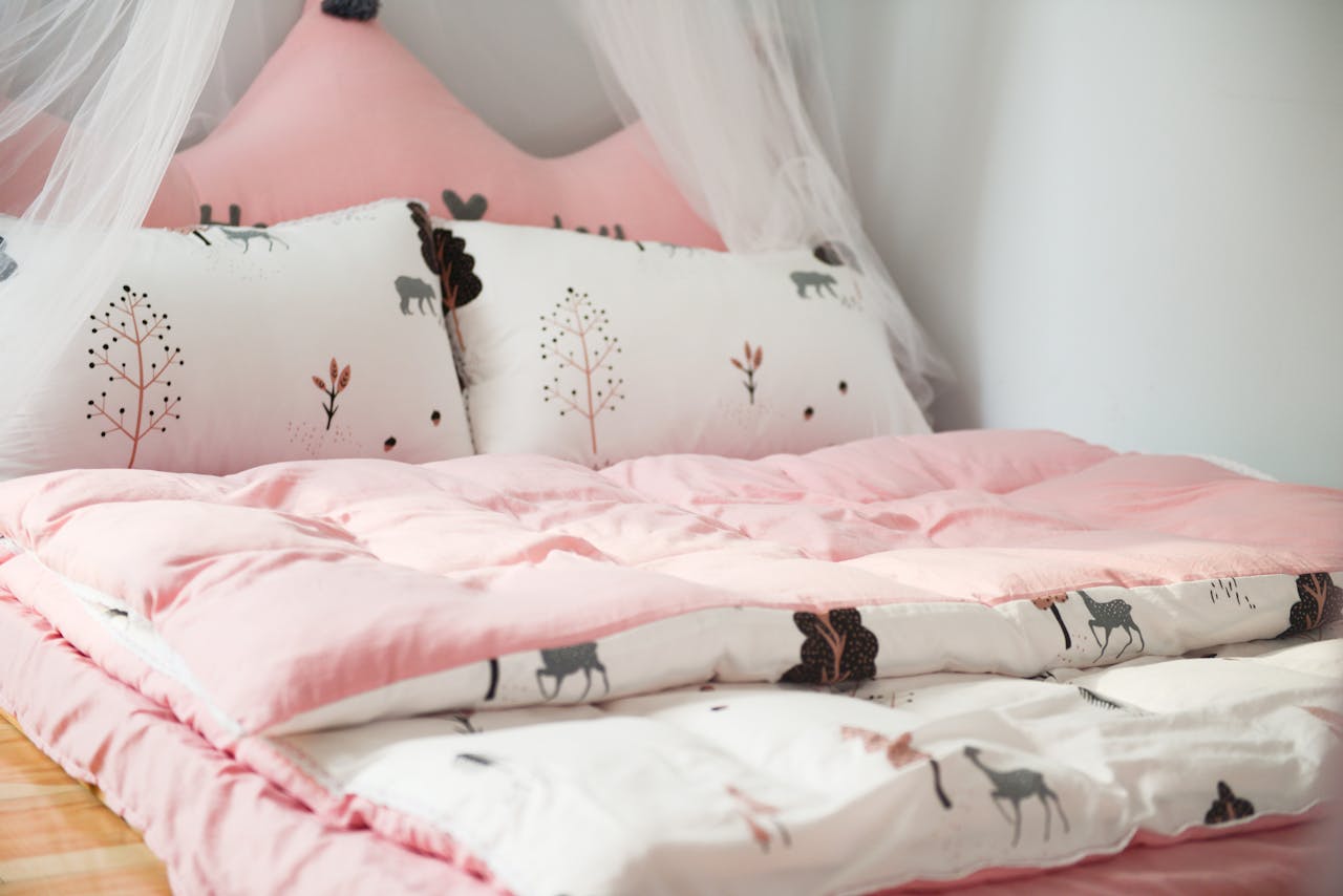Home A cozy bedroom with pink bedding and animal patterns, perfect for relaxation.